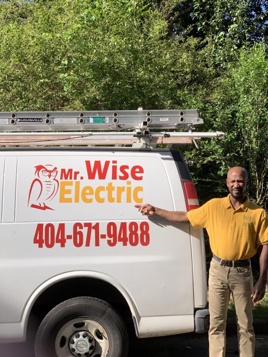 Mr. Wise Electric service worker next to branded van